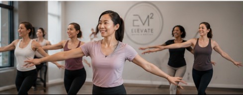 A group of women in a bright studio practicing barre and dance movement together, demonstrating grace, balance, and community