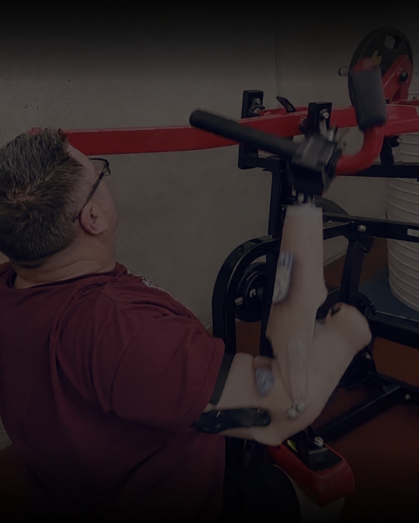 Client working on rehabilitation machine with prosthetic arm